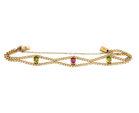 A peridot and pink tourmaline bracelet, the oval cut pink tourmaline flanked by oval cut peridots in yellow rubbed over setti