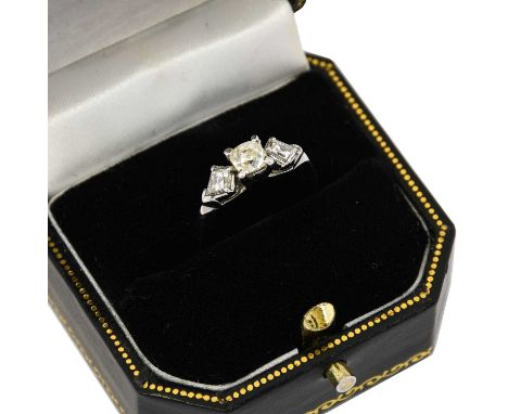 A diamond three stone ring, the old cut diamond flanked by kite-shaped diamonds in white claw settings, to a tapered shoulder