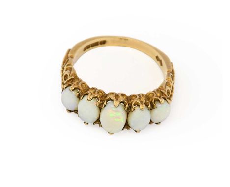 A 9 carat gold opal five stone ring, the graduated oval cabochon opals in yellow claw settings, to an elaborate gallery and s