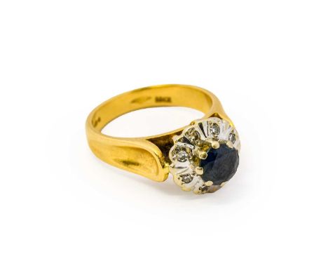 An 18 carat gold sapphire and diamond cluster ring, the round cut sapphire within a border of eight-cut diamonds, in white cl