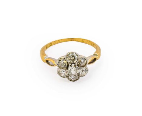 A diamond cluster ring, the central raised round brilliant cut diamonds within a border of round brilliant cut diamonds, in w