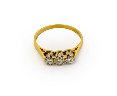 An 18 carat gold diamond three stone ring, the round brilliant cut diamonds in white claw settings, to a yellow tapered shoul