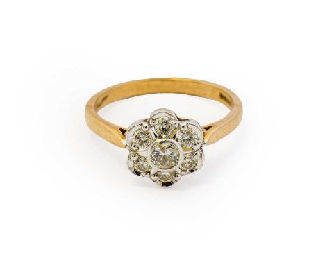 A 9 carat gold diamond cluster ring, the round brilliant cut diamonds in white rubbed over and claw settings, to a yellow tap