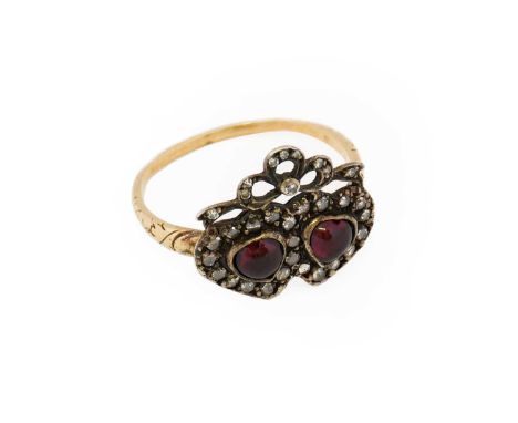 A garnet and diamond twinned heart ring, the heart shaped cabochon garnets within a rose cut diamond border, surmounted by a 