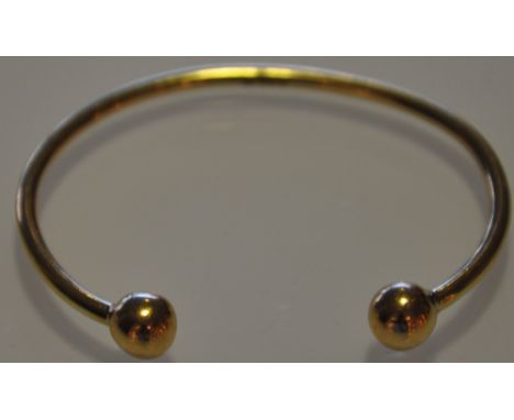 A 9ct gold bangle of customary form 