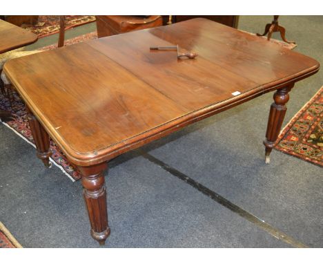 A Victorian mahogany wind out dining table, rounded square top, turned and reeded legs, brass terminals, ceramic casters, cir