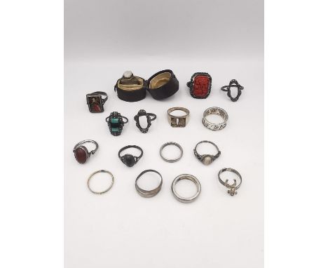 A collection of sixteen silver rings of various designs, including a carved cinnabar lacquer dress ring with peony design, a 