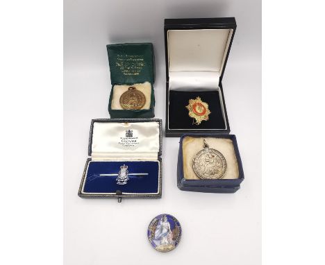 A collection of medals and badges, including two theatre medals, an enamelled coin brooch (enamel damaged), a silver bar broo