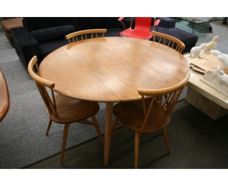 A light Ercol drop leaf table, 112cm x 125cm and a set of four stick back cross-over chairs, 78cm high