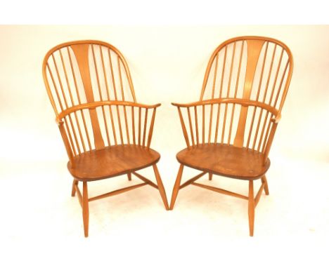 A pair of light Ercol stick back elbow chairs, 103cm high