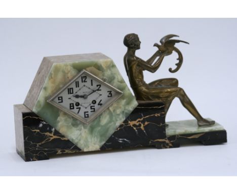 An Art Deco mixed marble mantel clock, having lozenge dial, L. Baron, Bordeaux, mounted with spelter figure of female, 26cm h