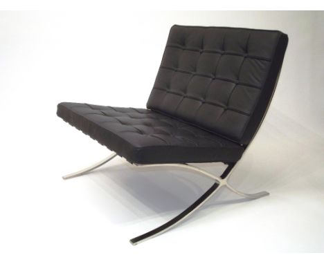 A Barcelona black leather buttoned down upholstered living chair, raised on metal X-frame support, 75cm; and matching foot st