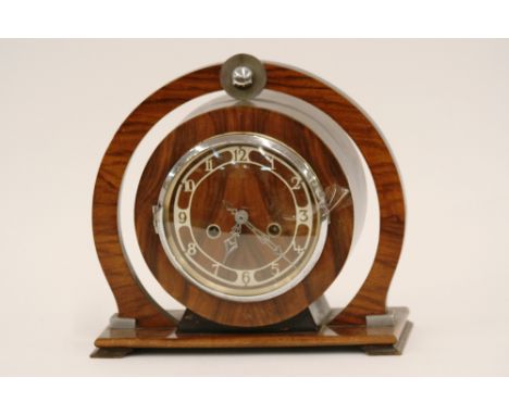An Art Deco walnut cased two hole mantel clock, of circular form, 29cm