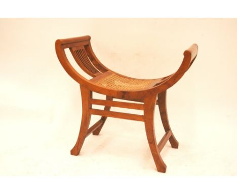 A beechwood cane seated stool, raised on outswept supports united by stretchers, 66cm high in extremes