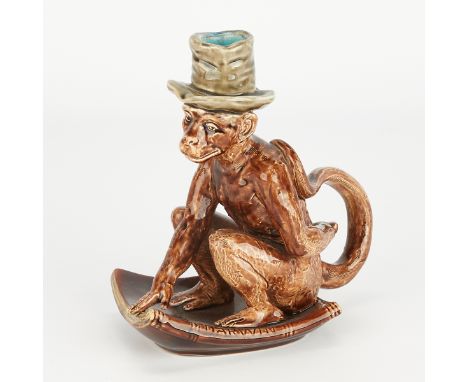 Sarreguemines, French. Majolica ceramic candlestick in the form of a monkey in a top hat perched atop a book stamped "Darwin,