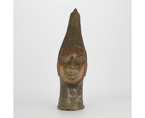 Modern Benin bronze head in the form of a figure wearing a tall cylindrical cap.Height: 21 1/2 in x width: 5 3/4 in x depth: 