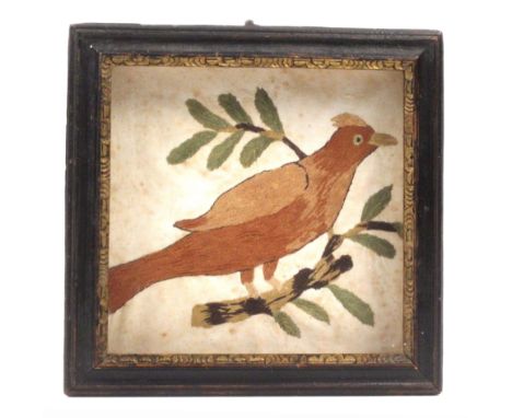 An 18th Century silk embroidered panel depicting a bird on a leafy branch, in a black painted moulded glazed frame with paint