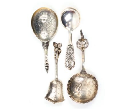 Four continental silver caddy spoons, comprising a Dutch example, the bowl with a man and child in a garden, 12cms, another w