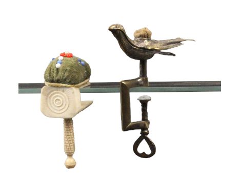 Two sewing clamps, comprising a silver plated brass hemming bird clamp, the sprung bird with pin cushion to back and stamped 