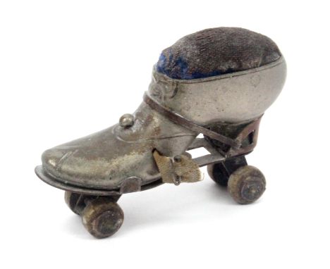 A novelty tape measure/pin cushion in the form of a roller skate, in plated brass, complete tape a little grubby, wound from 