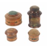 Four whitewood variously decorated Tunbridge ware pin cushions, comprising a cylinder box form