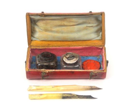 A charming late 18th Century travelling writing case in grained red leather and of trunk form, near oval in section, twisted 