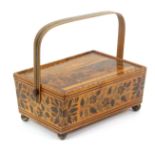 A whitewood print and paint decorated Tunbridge ware rectangular sewing pannier, raised on brass
