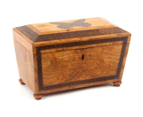 A golden figured oak Tunbridge ware tea caddy, of sarcophagol form, the front with a geometric mosaic banding, the canted lid