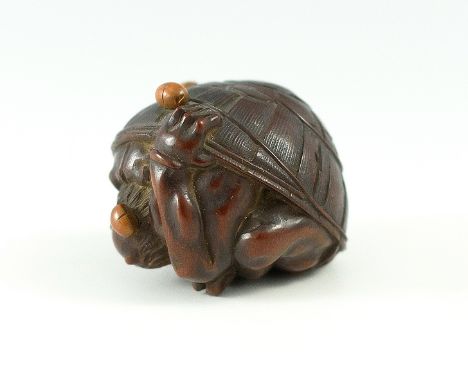 {Oni versteckt sich unter einem Hut vor den Bohnen} (Setsubun). Dunkelbraunes Holz, die Bohnen helleres Holz, sign. Masa-kazu