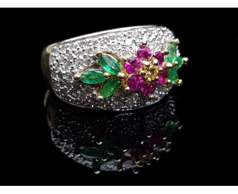 A diamond, emerald and ruby ring, formed as a ruby flower with yellow diamond centre, flanked by three marquis shaped emerald