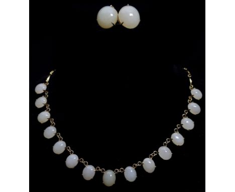 A greenish 'white jade' set necklace composed of fifteen oval stones on yellow metal chain; and a pair of circular earrings (