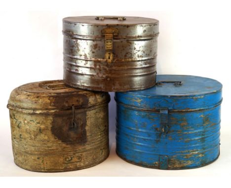 A group of three metal vintage hat boxes
Each of oval form with lockable clasps and hinged covers revealing empty hat compart