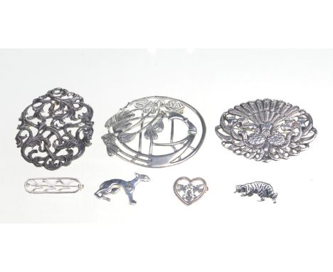 A collection of white metal brooches
Varying in design, to include; a Scottish Celtic brooch, a peacock brooch, a scroll broo