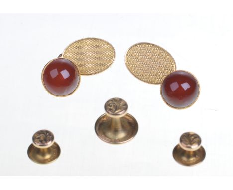 A cased set of carnelian cufflinks and gold studs,
The cabochon-cut carnelian, collet set, to engine turned oval gold backs, 
