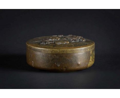  A circular brass box and cover decorated with two figures engaged in a ritual Japan, Meiji period, 1868 - 1915 The cover wit