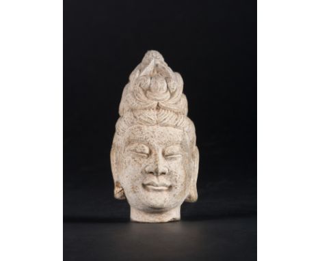  A carved stone head of Guanyin China, Tang dynastyCharacterized by a serene expressione and elaborated headdress. Old red la