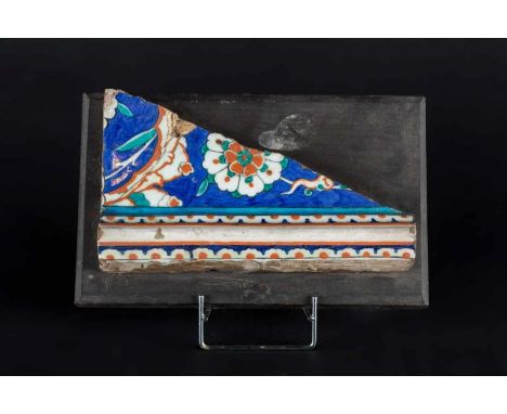 A fragment of Iznik border tile decorated with split palmete and carnation Turkey, late 16th century Cm 24,50 x 14,50 22.00 