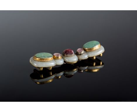  A jade buckle with ruby and semi precious stonesIndia or Turkey, 17th century Cm 2,50 x 10,00 22.00 % buyer's premium on the