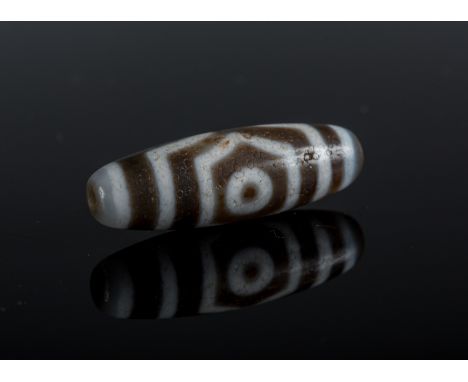  An agate three eyed dzi Tibet Cm 1,00 x 4,00 22.00 % buyer's premium on the hammer priceVAT margin scheme, VAT included, but