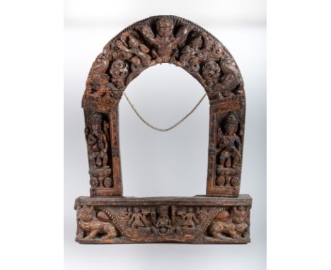  A wooden carved turana Nepal, 18th century Turana, in all likelihood originally from a small temple, portraying in the cente
