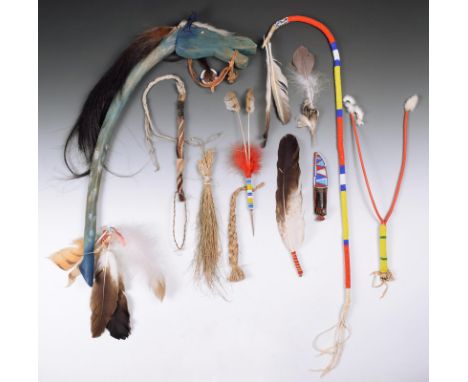 A Lakota dance stick  wood, horse hair, hide, glass beads, feathers, bells and brass tacks, modelled as a horse's head and a 