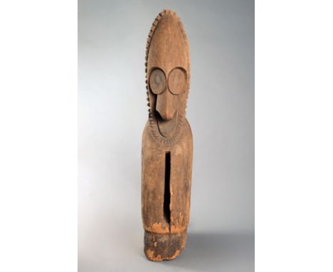 A Vanuatu slit drum Melanesia with an ancestor head finial having a pointed bead coiffure and collar, large eyes and nose, wi