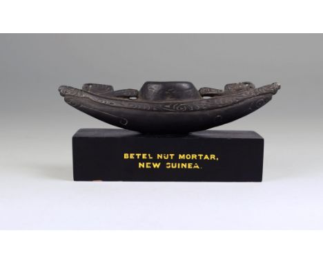 A Massim betel nut mortar Trobriand Islands, Papua New Guinea of canoe form with pierced and carved scroll decoration, the ce