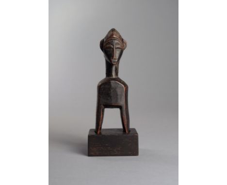 A Baule heddle pulley Ivory Coast with a head finial having a crested and ribbed coiffure, with raised scarifications to the 