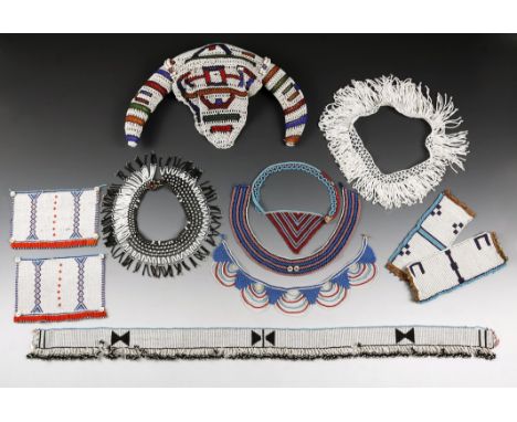 A Zulu beaded waistband South Africa white with black geometric designs, a blue edge and with a fringe and mother of pearl bu