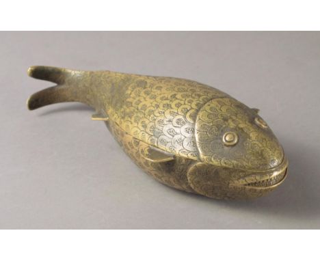 A Benin kola nut container Nigeria brass modelled as a fish and decorated scales, with a lift off cover, 25cm long.