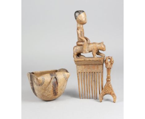 An Akan comb Ghana with a male figure riding a leopard, 32.5cm high, a Baule catapult, 16cm long and a Turkana bowl, 11cm hig