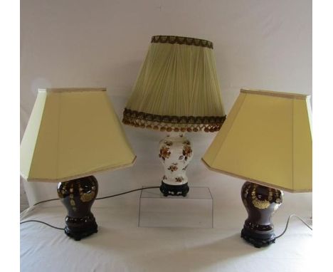 Pair of ceramic table lamps on Oriental wooden stands and one other of the same design (not tested)