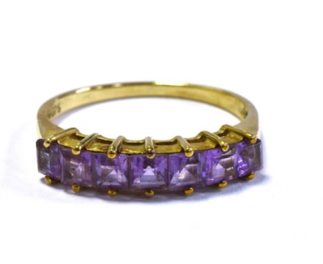 9CT GOLD &amp; AMETHYST SEVEN STONE RING claw set with carre cut amethysts, ring size P 1/2, stamped '375'.  Weight 1.8 grams