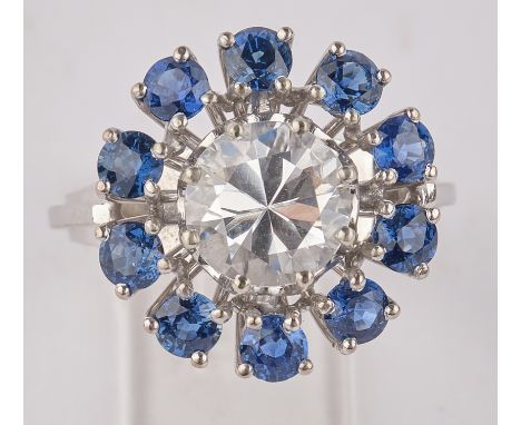 Ceylonsaphir-Ring, WG 750, Handarbeit, zentraler weißer Ceylon-Saphir ca. 2.50 ct., entouriert von 10 blauen Saphiren zus. ca